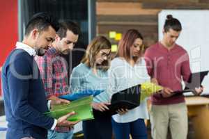 Business executives looking over file in office