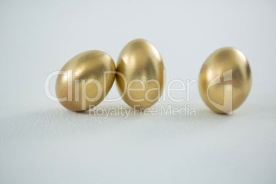 Golden Easter eggs on white background