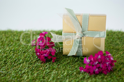 Gift box with flowers on grass