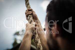 Man climbing a rope during obstacle course