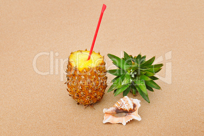composition of juicy pineapple and sea shells on sand background