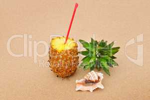 composition of juicy pineapple and sea shells on sand background