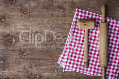 Wooden kitchen items on a red napkin, rolling pin and hammer for