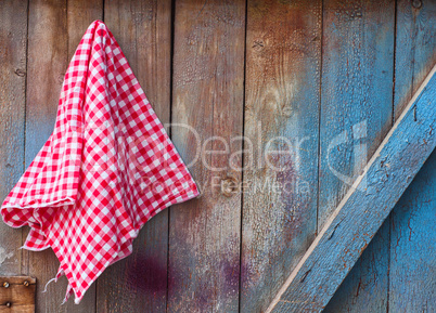 Red cloth in a cell hanging on a wooden cracked wall