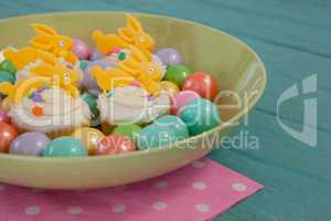 Colorful chocolates and cupcakes in bowl