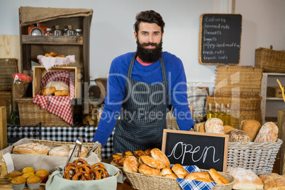 Portrait of smiling male staff standing at counter