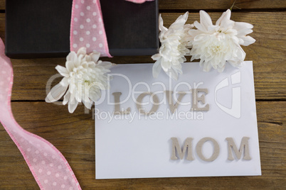 Gift box with love mom text on wooden plank