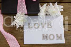 Gift box with love mom text on wooden plank