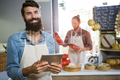 Portrait of smiling staff using digital tablet