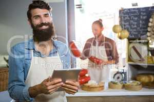 Portrait of smiling staff using digital tablet