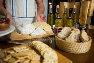 Staff standing near various cheeses at counter