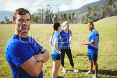 Fit man standing with arms crossed in boot camp