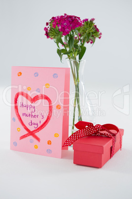 Happy mothers day greetings with gift box and flower vase