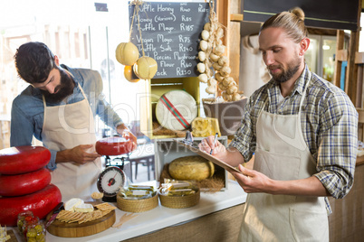 Salesman writing on clipboard at counter in grocery shop