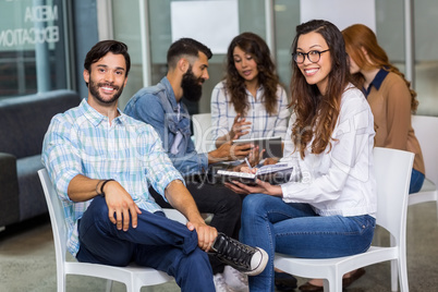 Portrait of male and female executives sitting in meeting