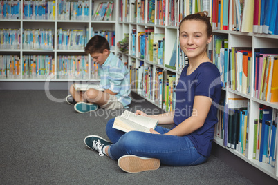 School kids reading books in library at school
