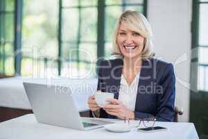 Businesswoman holding coffee cup in a restaurant