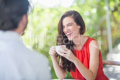 Beautiful woman laughing while having coffee