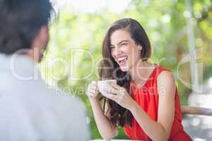 Beautiful woman laughing while having coffee