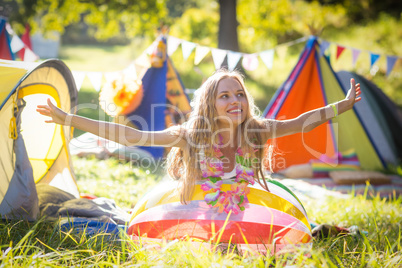 Woman leaning on beach ball at campsite