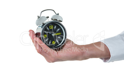 Hand of executive holding alarm clock