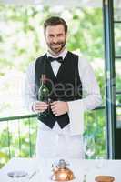 Male waiter holding bottle of wine