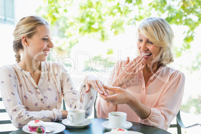 Woman showing engagement ring to her friend