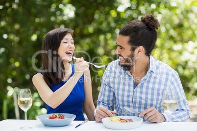 Woman feeding food to man