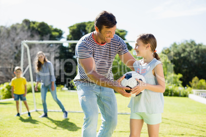 Family playing football together at the park