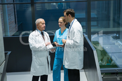 Doctors and surgeon interacting with each other in corridor