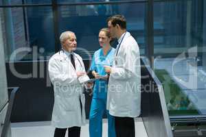 Doctors and surgeon interacting with each other in corridor