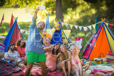 Man taking a selfie with friends at campsite