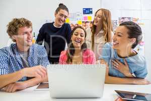 Executives discussing over laptop in office