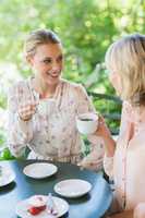 Smiling friends enjoying coffee together