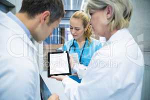 Medical team discussing over digital tablet