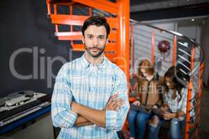 Male executive standing with arms crossed in office