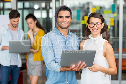 Portrait of executives using laptop