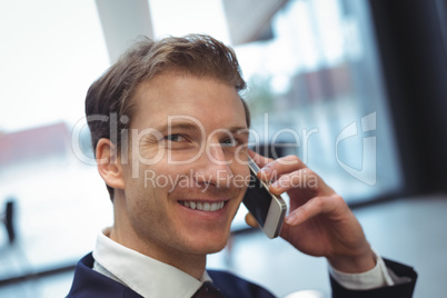 Businessman talking on mobile phone at office