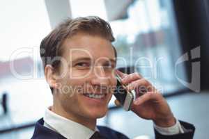 Businessman talking on mobile phone at office