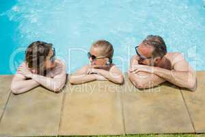 Happy parents and daughter relaxing in pool