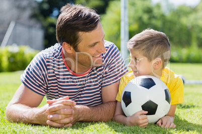 Father and son lying on grass in the park