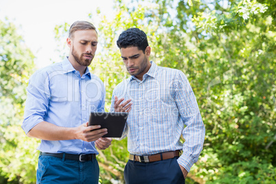 Executives discussing over digital tablet