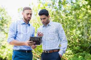 Executives discussing over digital tablet