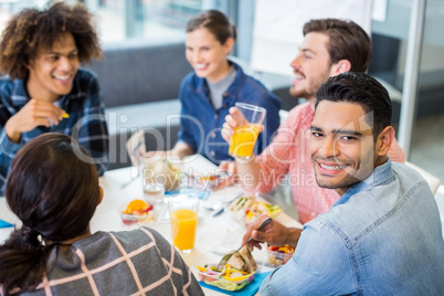 Portrait of happy male executive having breakfast