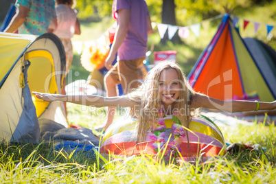 Woman leaning on beach ball at campsite