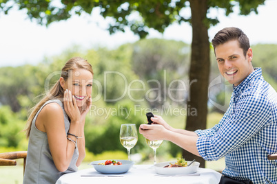 Man proposing to woman offering engagement ring