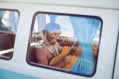 Man playing guitar in campervan