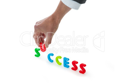 Hand of businessman arranging success word