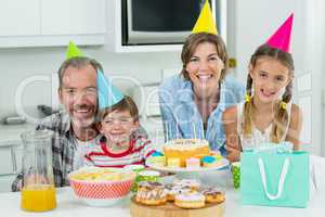 Smiling family celebrating a birthday together in kitchen