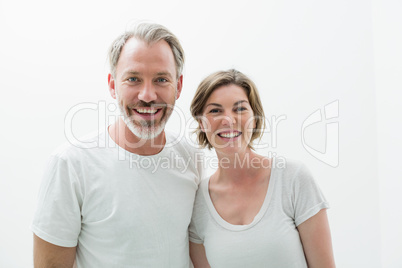 Smiling couple in white t-shirt in bedroom at home